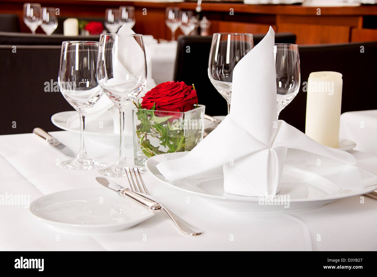 tables in restaurant with white tablecloth and elegant dish and silverwear Stock Photo