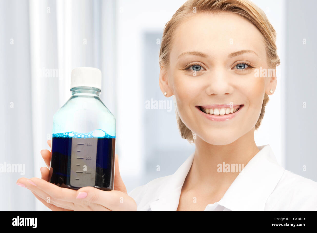 lab worker holding up bottle with blue liquid Stock Photo Alamy