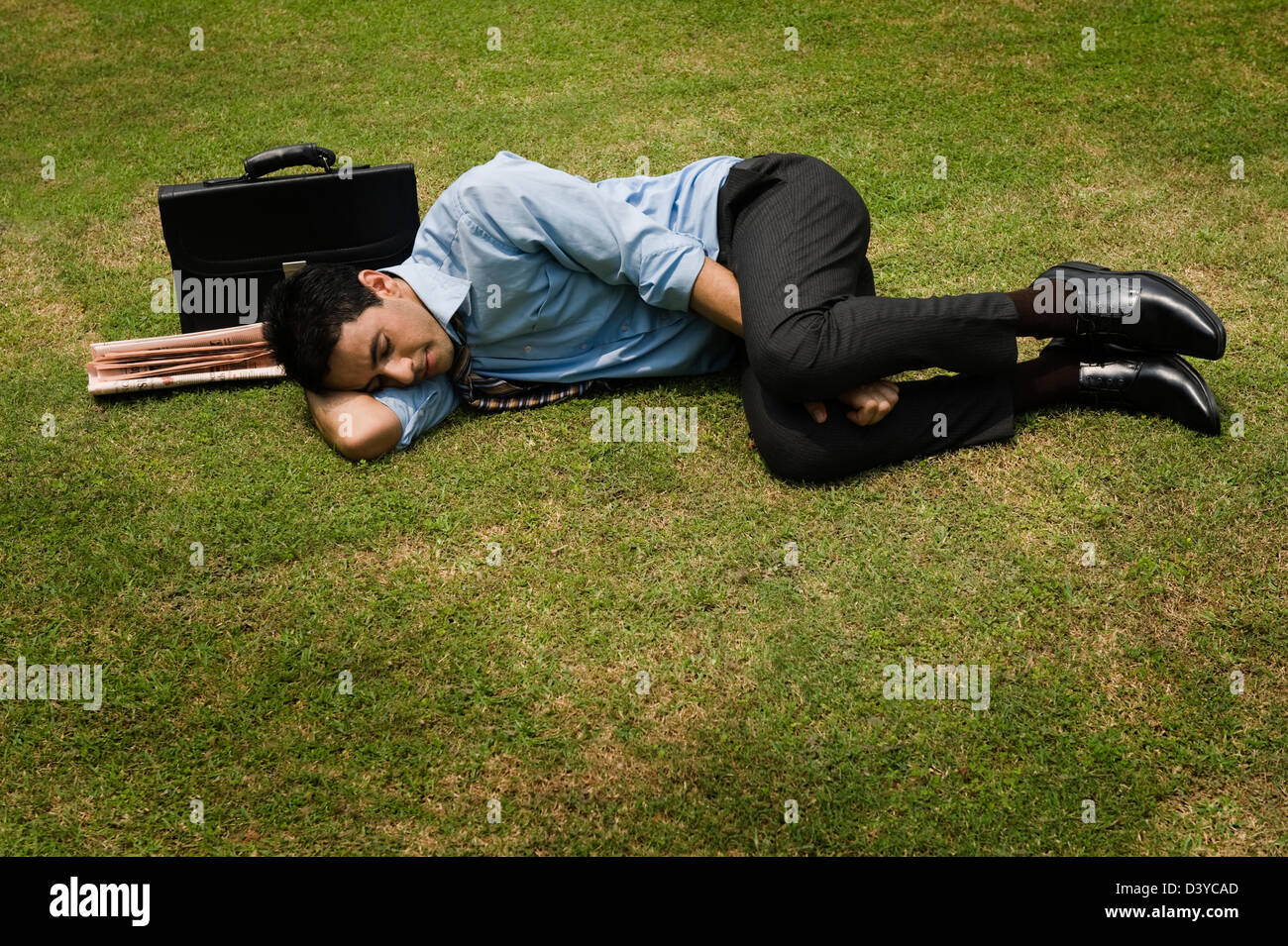 Businessman sleeping in a park Stock Photo Alamy