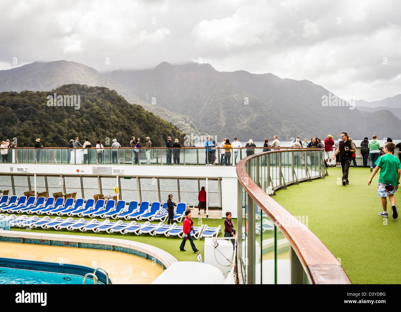 Cruise ship passengers on deck viewing spectacular Milford Sound, South Island, New Zealand Stock Photo