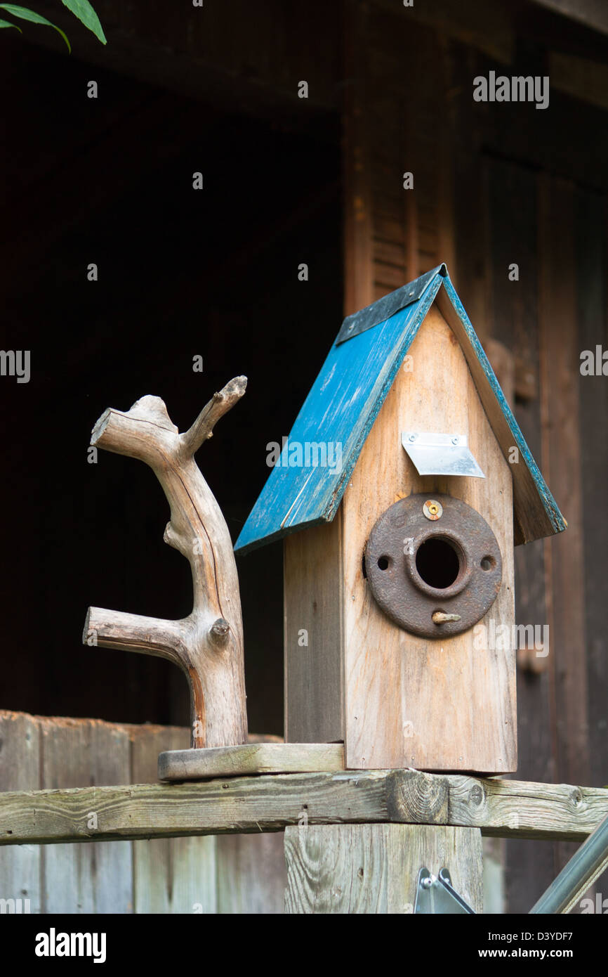 a rustic birdhouse with blue roof Stock Photo