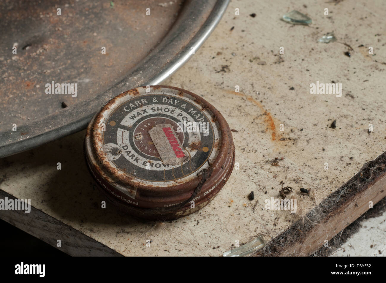 Old rusty shoe polish tin in derelict abandoned house kitchen next to pewter tray on dusty worktop with broken glass Stock Photo Alamy
