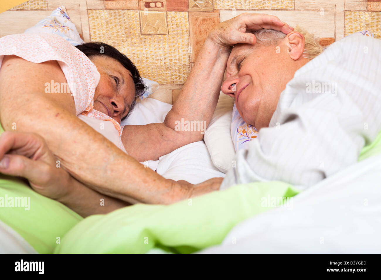 Close up of happy loving senior couple relaxing in bed. Stock Photo