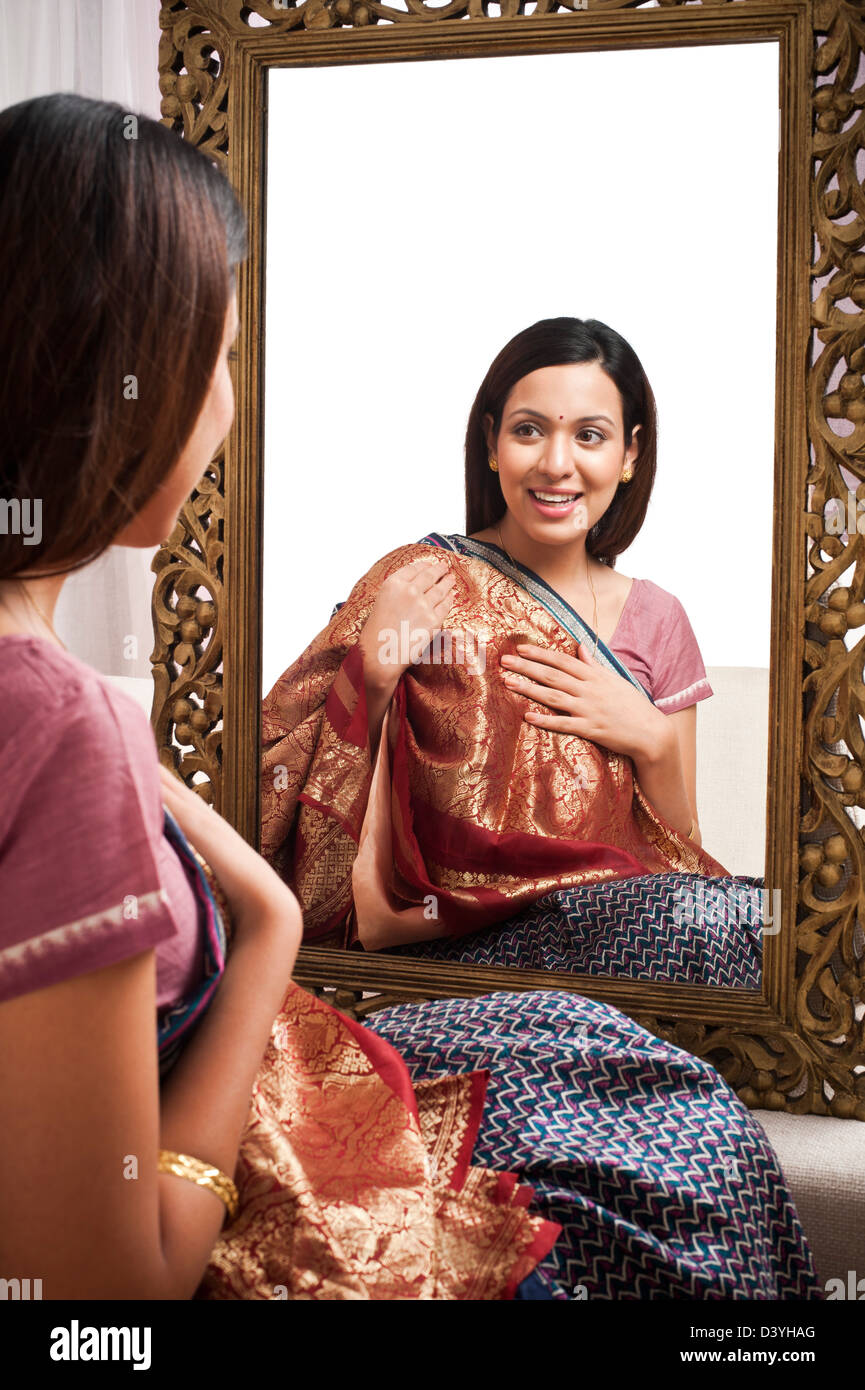 Reflection of a woman in mirror trying a sari on herself Stock Photo