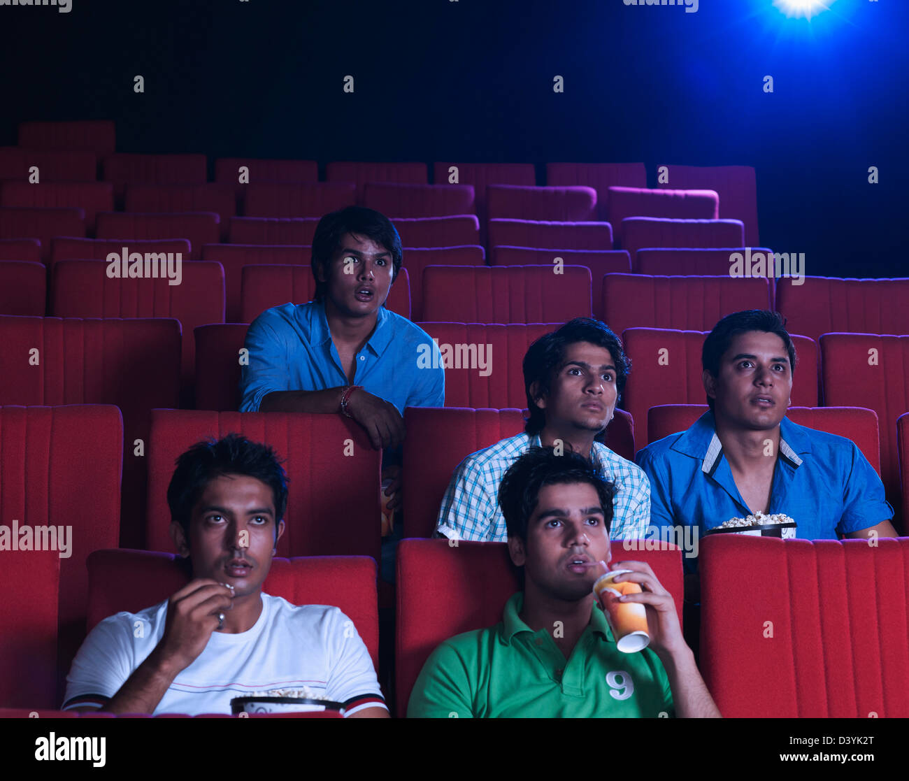 Youngsters enjoying movie in a cinema hall Stock Photo
