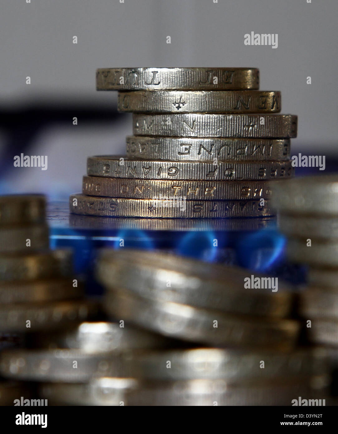 Lots of coin around a gas burner on a cooker. The owner of British Gas, Centrica, has seen operating profits rise by 14%. Stock Photo