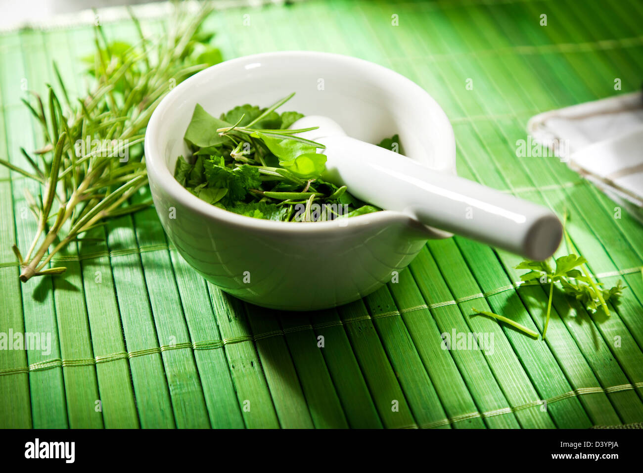 Herbal medicine concept - variety of herbs in ceramic mortar with pestle on  green bamboo mat Stock Photo - Alamy