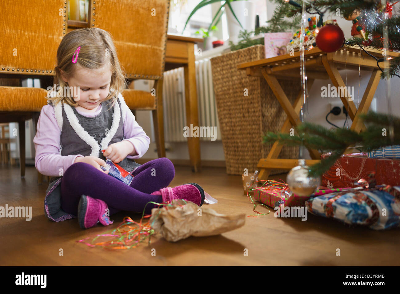 Girl on at Home Opening Christmas Present, Germany Stock Photo