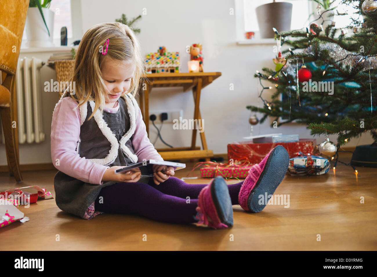 Girl on at Home Opening Christmas Present, Germany Stock Photo