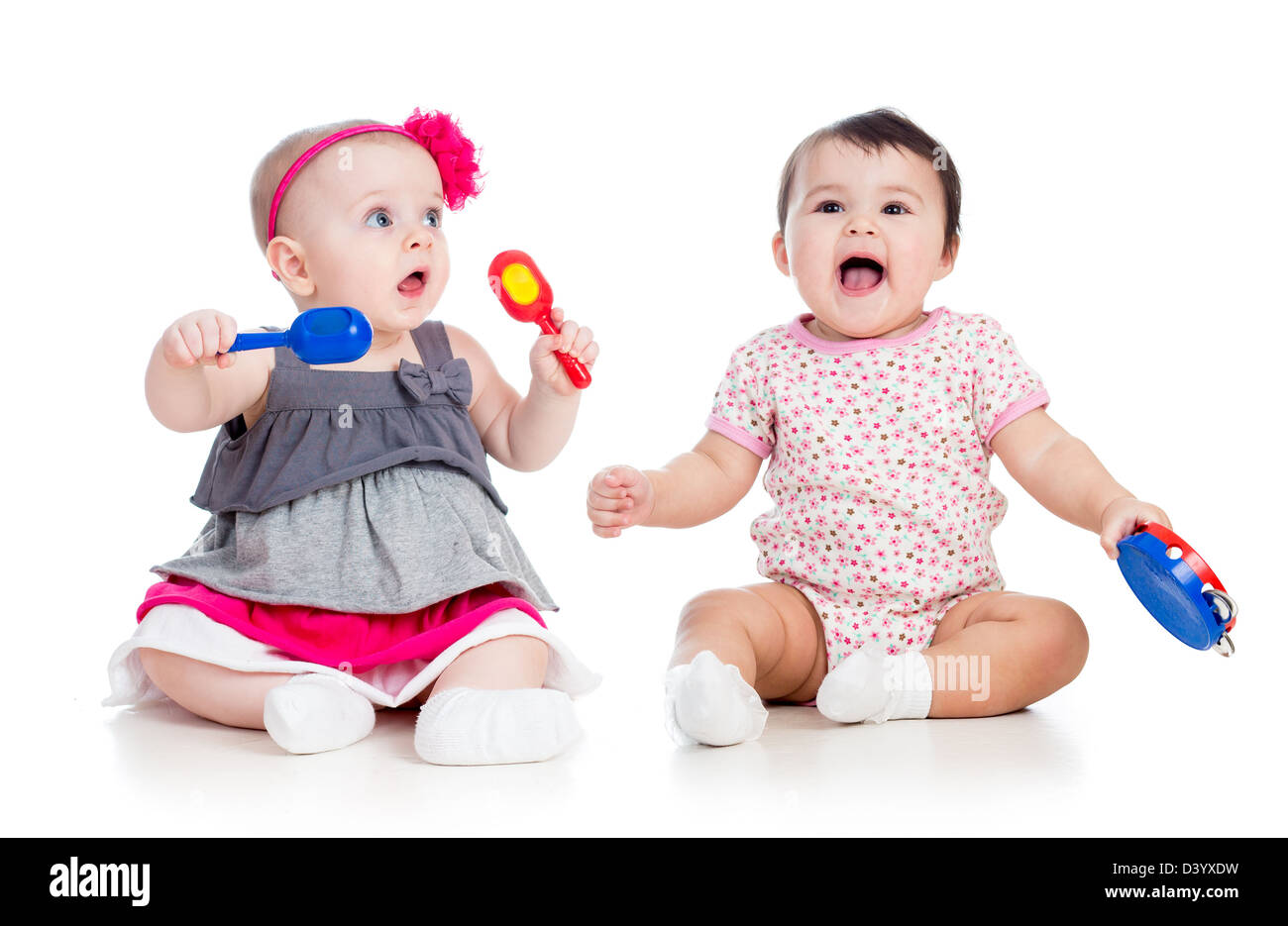 Funny babies girls with musical toys. Isolated on white background Stock Photo