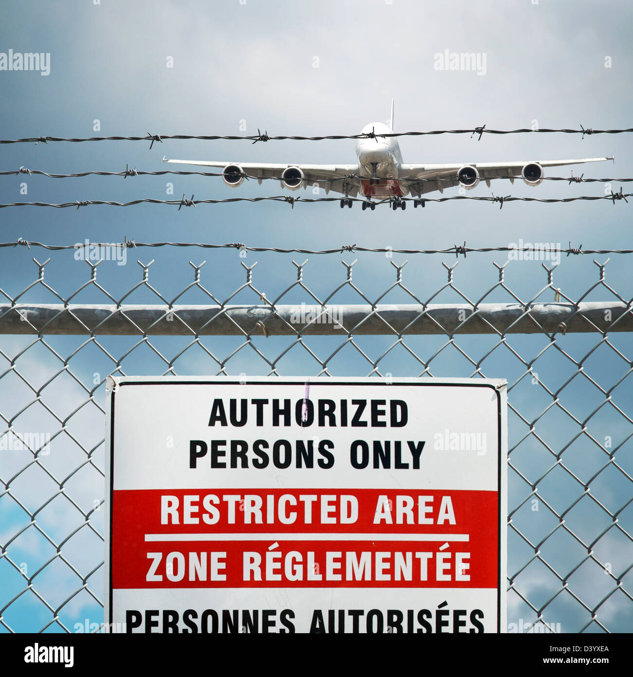 Jumbo Jet and Restricted Area Sign on Chain Link Fence with Barbed Wire, Pearson International Airport, Toronto, Ontario, Canada Stock Photo