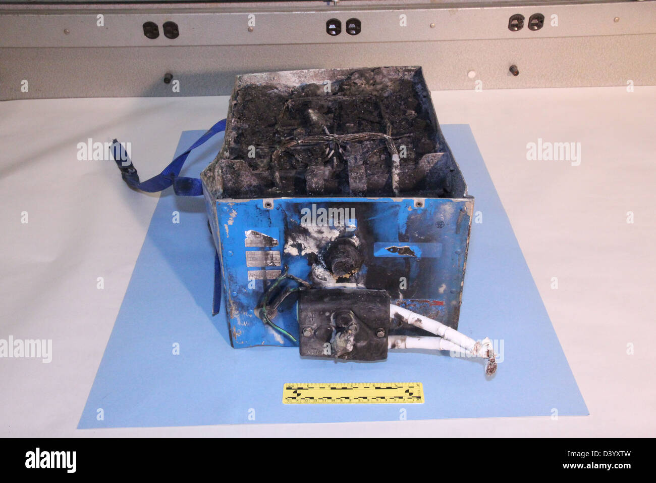 NTSB photos of the burned auxiliary power unit battery from a JAL Boeing 787 that caught fire on January 7, 2013 at Boston's Logan International Airport. The dimensions of the battery are 19x13.2x10.2 inches and it weighs approximately 63 pounds Stock Photo