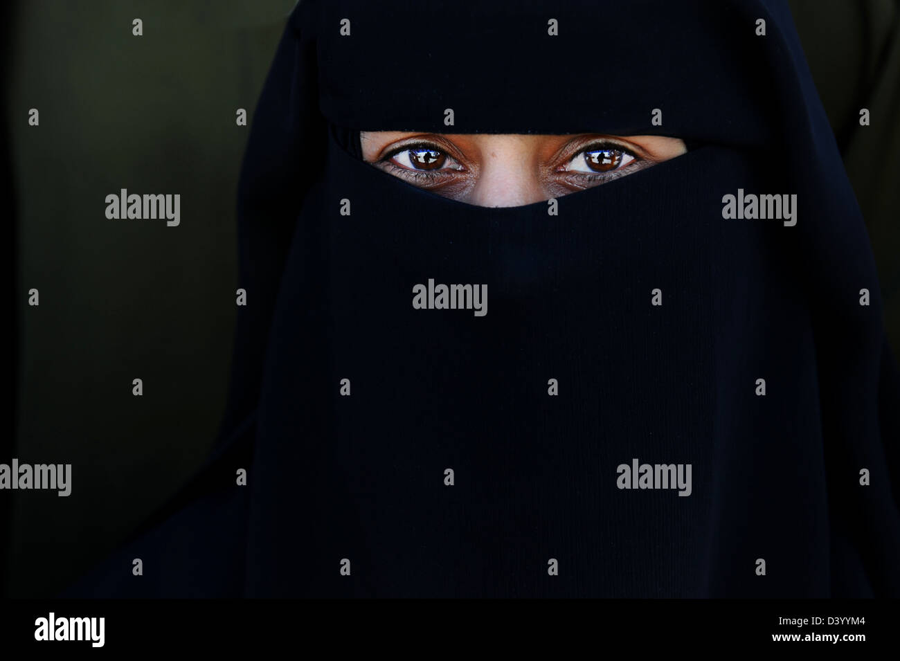 Young women wearing traditional black clothing leaving only her eyes ...