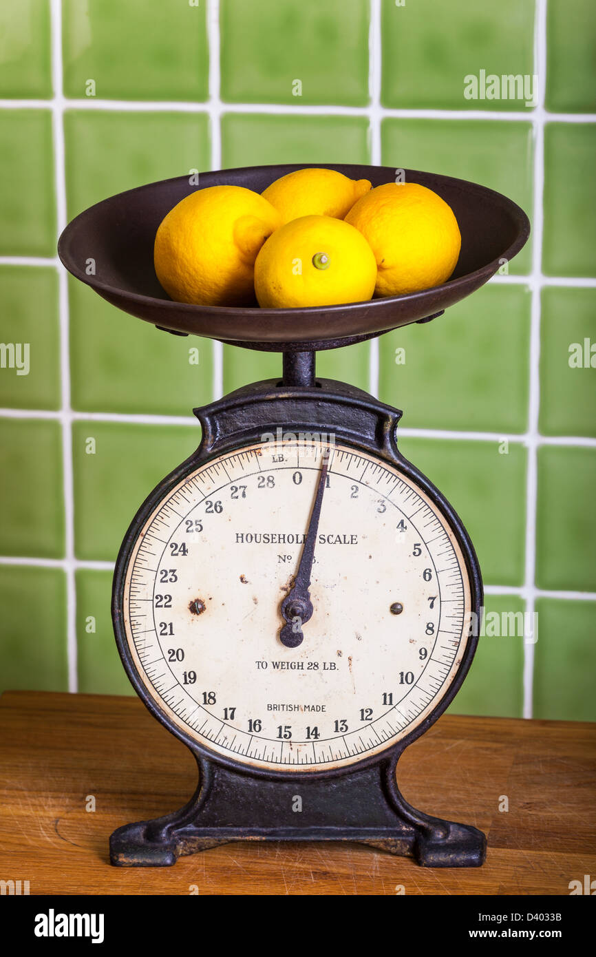 Old mechanical kitchen scales with lemons in the pan Stock Photo