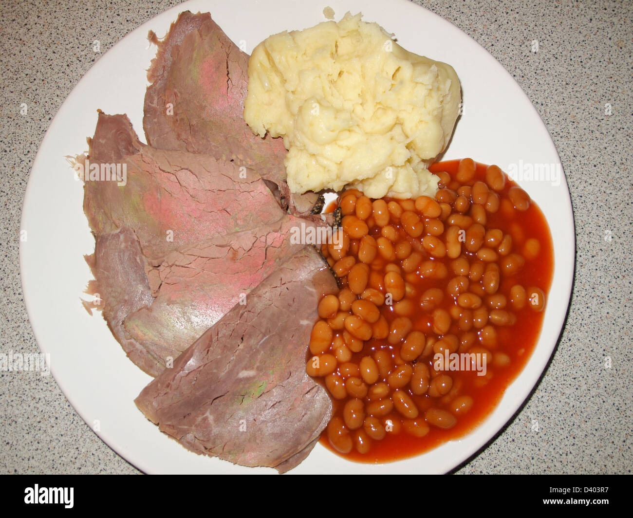Cold roast silverside of beef with baked beans and mashed potato on