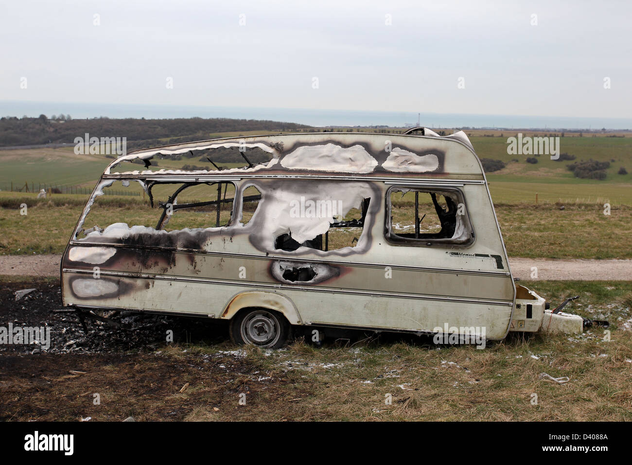 A burnt out caravan on a travelers site in Devils Dyke, Brighton, East Sussex, UK. Stock Photo