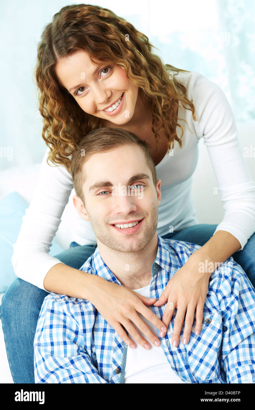 Young happy couple looking at camera while resting at home Stock Photo ...