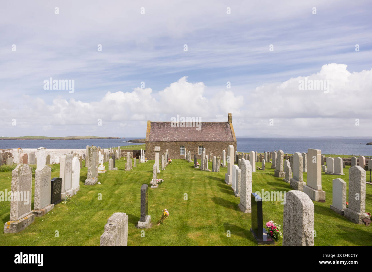 Tiny church of St Margaret's Kirk is now disused with gravestones in the churchyard on coast at Sandness, Shetland Islands, Scotland, UK Stock Photo