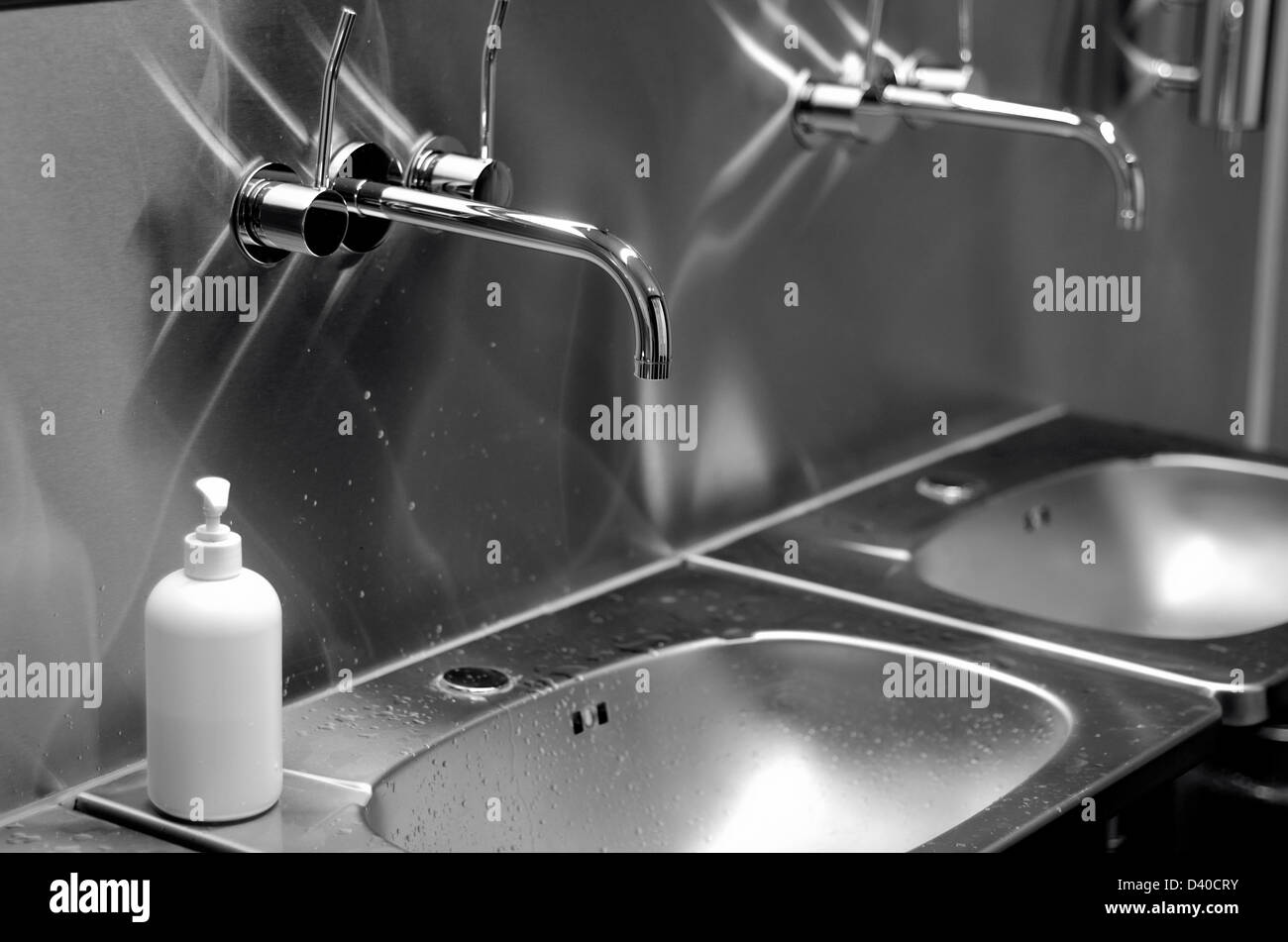 faucets, sinks and liquid soap in a public toilet Stock Photo