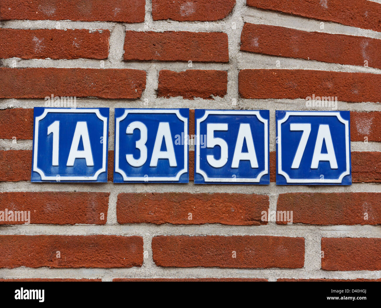 Multiple house numbers on wall Stock Photo