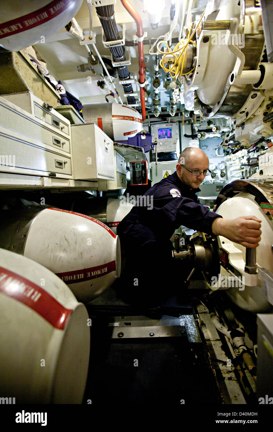 Crew Man With Hand On Lever In Torpedo Room Of Nuclear