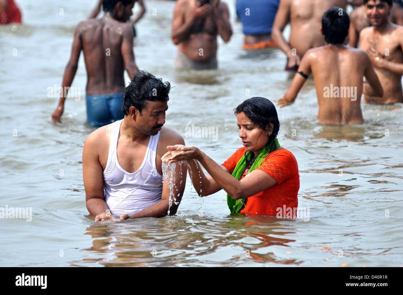 A Hindu couple pray at the bank of Sangam confluence of river Ganga, Yamnuna and mythical Saraswati during Kumbh Stock Photo