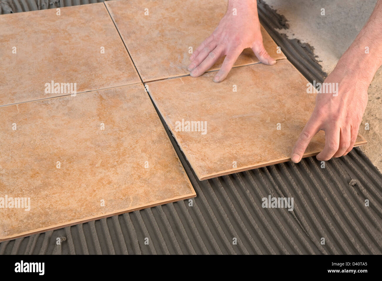 gluing tiles laid on the adhesive Stock Photo