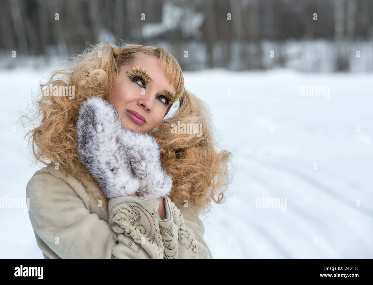 Giddy young woman with exaggerated cilia in a winter field Stock Photo