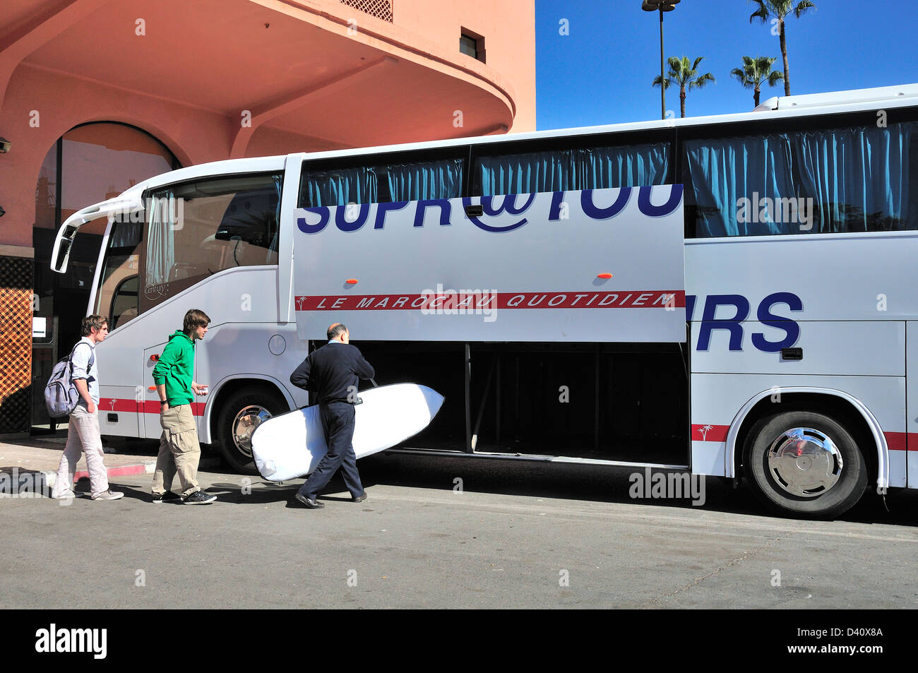 Surfboard being loaded into hold of Moroccan long distance Supratours coach at the main coach station in Marrakech, Morocco, North Africa Stock Photo