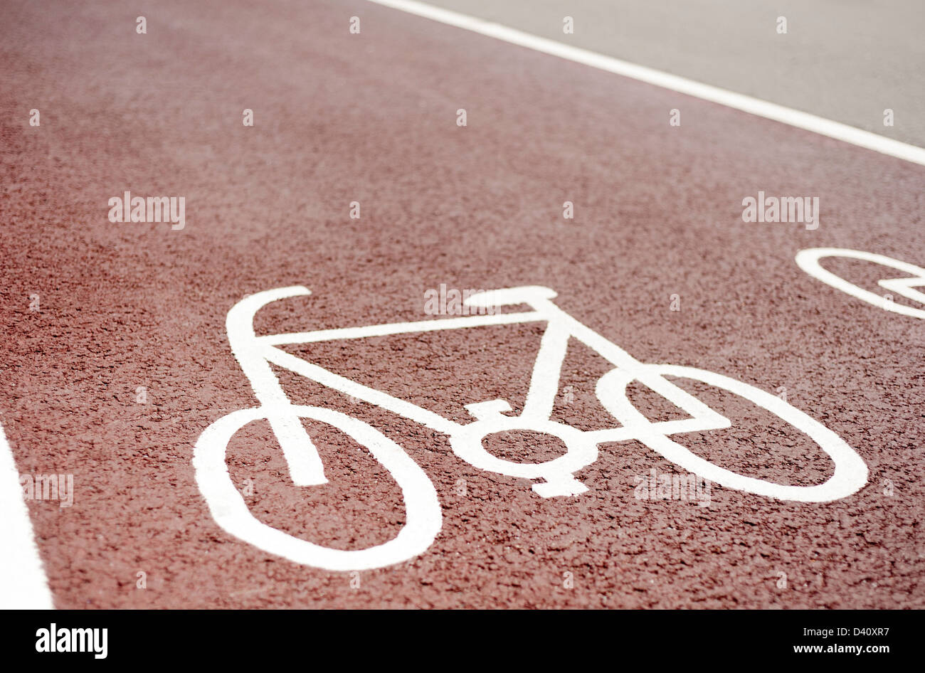 Designated cycle lane path symbol painted on a red asphalt road surface, UK Stock Photo