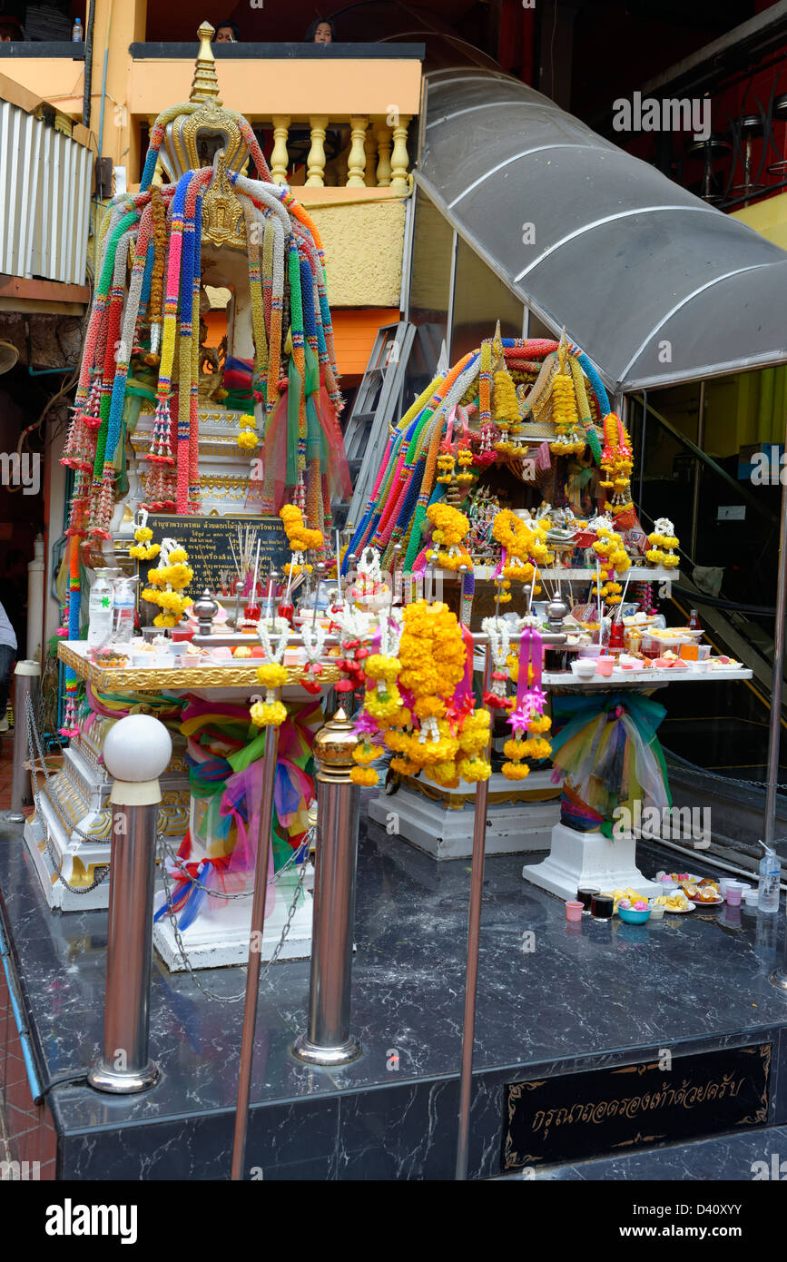 Buddhist street shrine in Bangkok with flowers Stock Photo