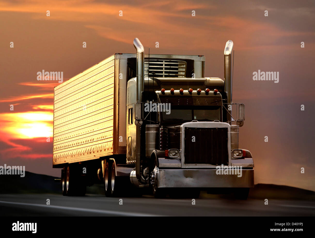 semi truck driving on highway at sunset Stock Photo