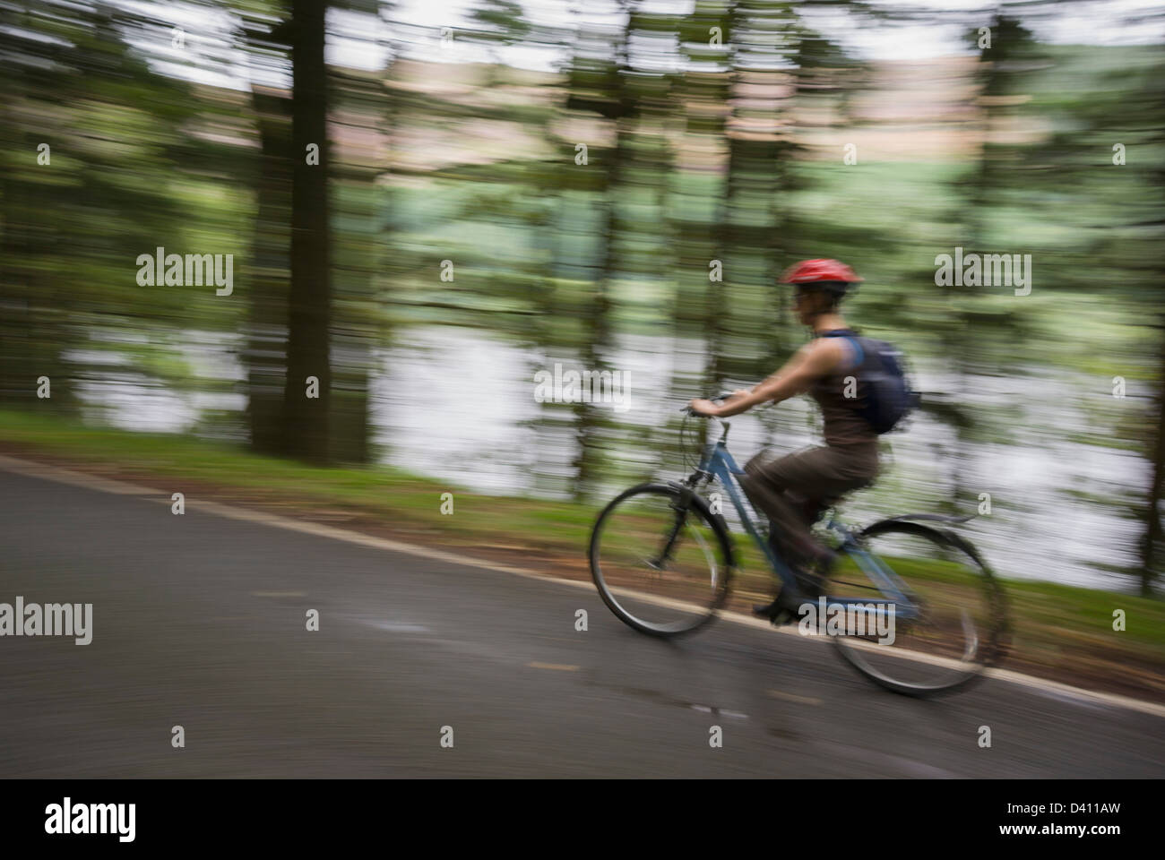 Woman enjoying a fast bike ride, Lake Vyrnwy Stock Photo