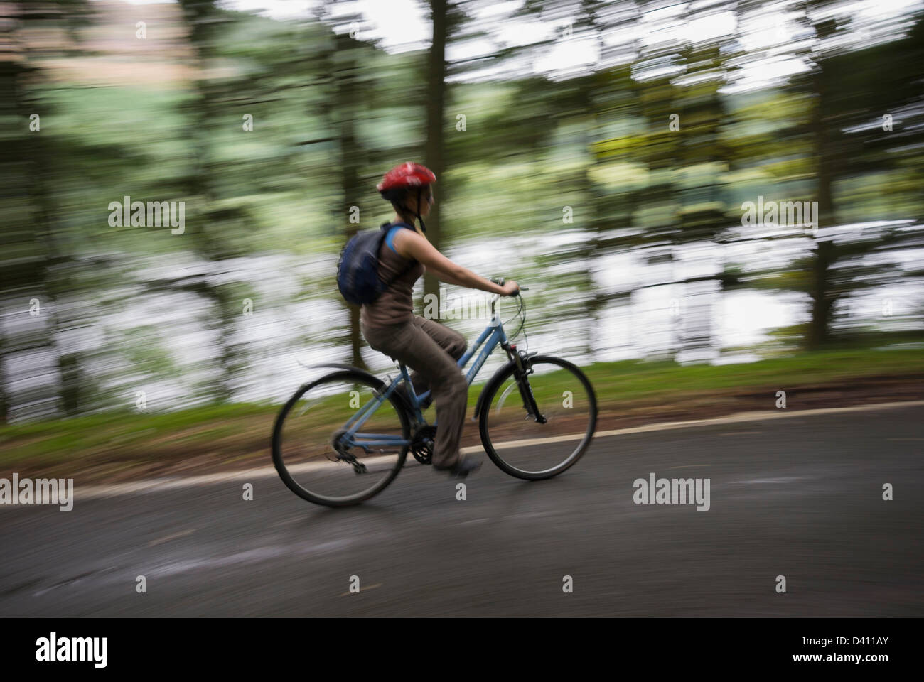 Woman enjoying a fast bike ride, Lake Vyrnwy Stock Photo