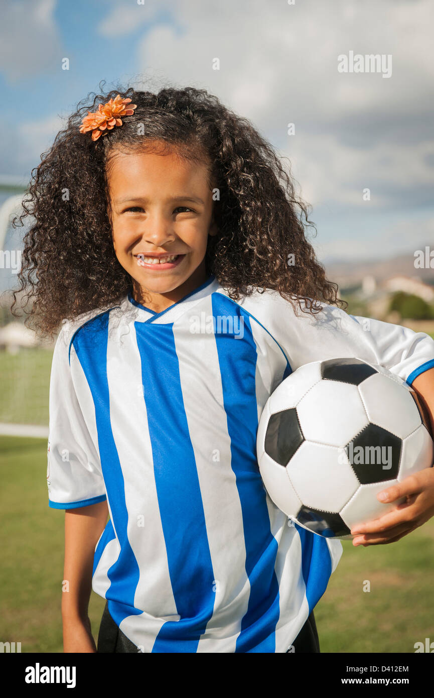 Mixed race girl holding soccer ball Stock Photo Alamy