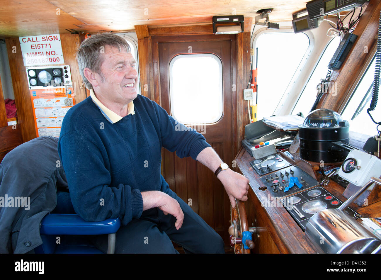 Ferryman steering ferry, County Cork, Ireland Stock Photo