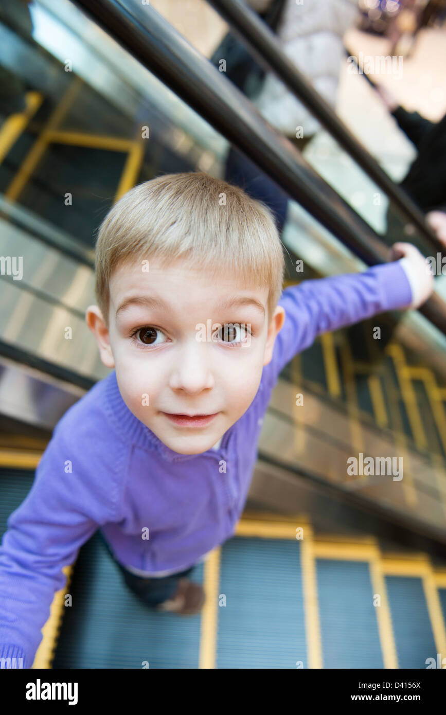 Cute little boy on escalator in mall Stock Photo
