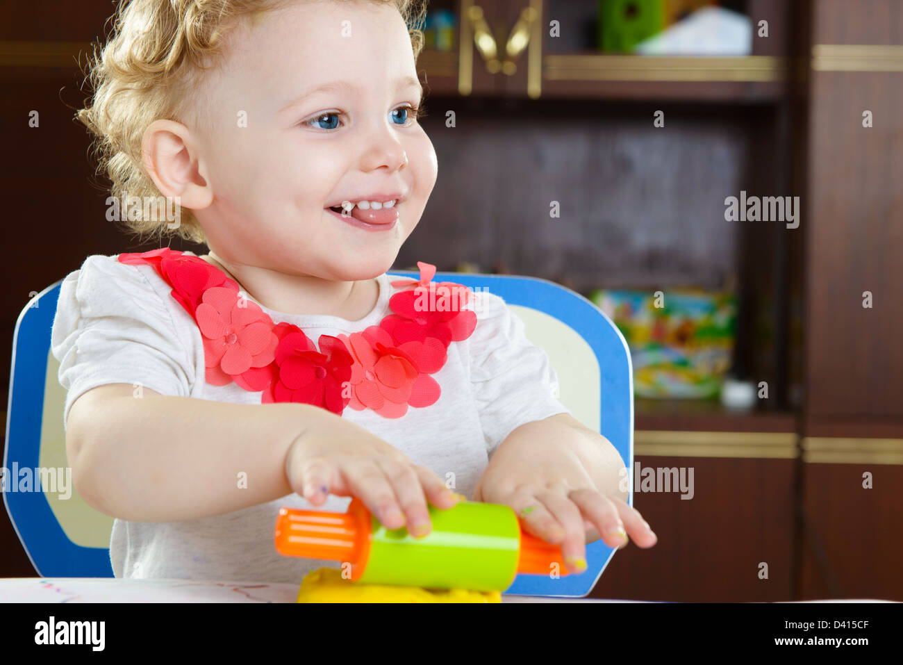 Cute smiling girl rolling plastiline dough at home Stock Photo - Alamy