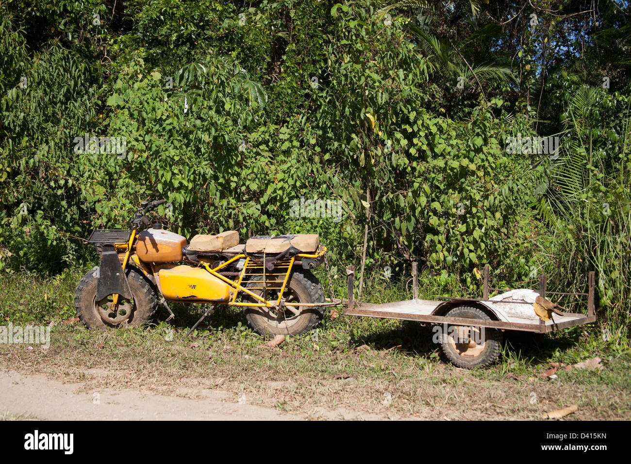 Old, used and small motorcycle with knobby tires and little trailer. Stock Photo