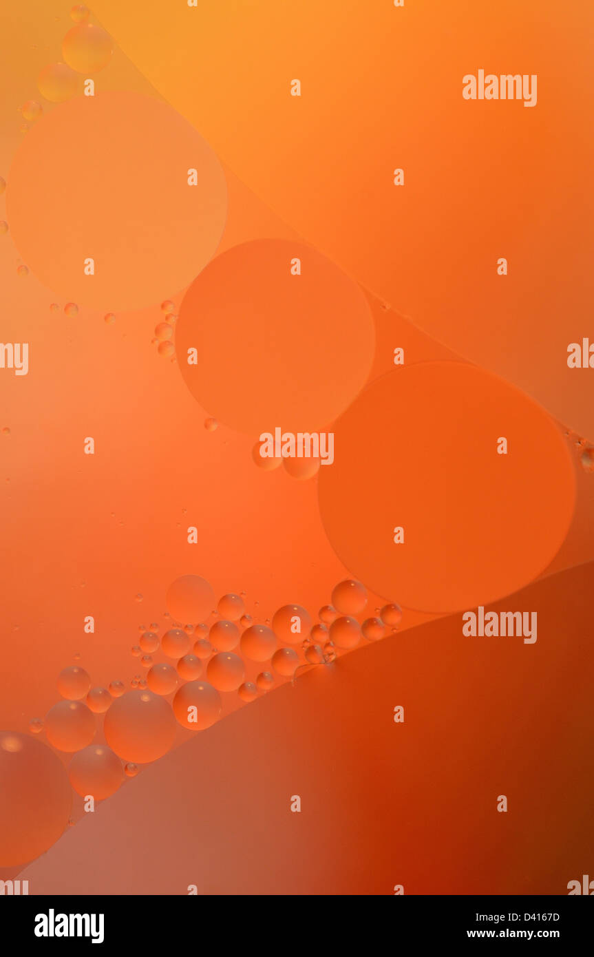 Abstract red, orange background from floating oil bubbles in the water. Stock Photo