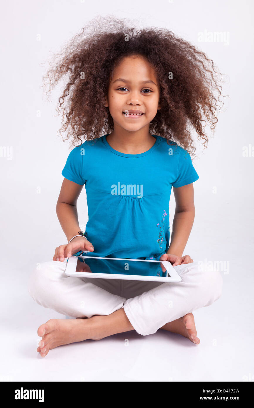 Little african asian girl using a tablet pc, isolated on white ...