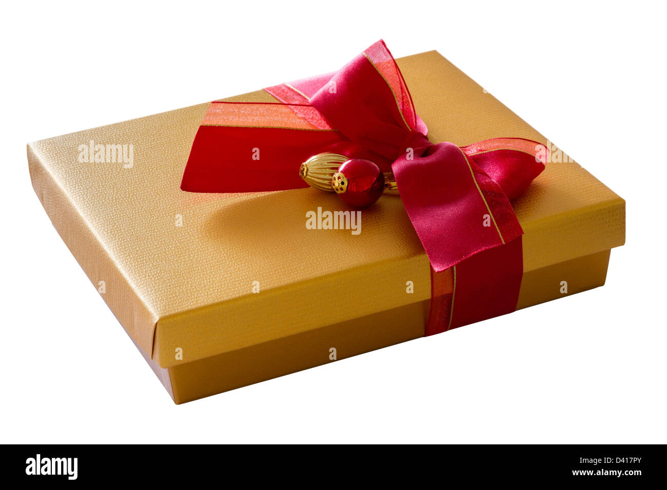 Isolated gold colored cardboard gift box on white background with red ribbon bow and decorations Stock Photo