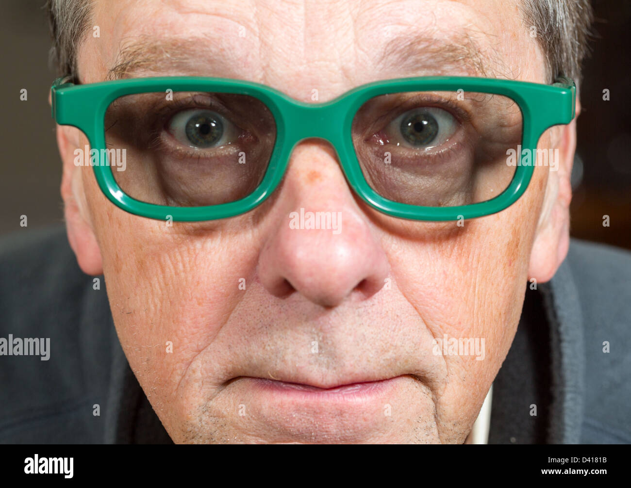 Senior male with shocked expression watching movie in 3d glasses with tight focus on face and eyes Stock Photo