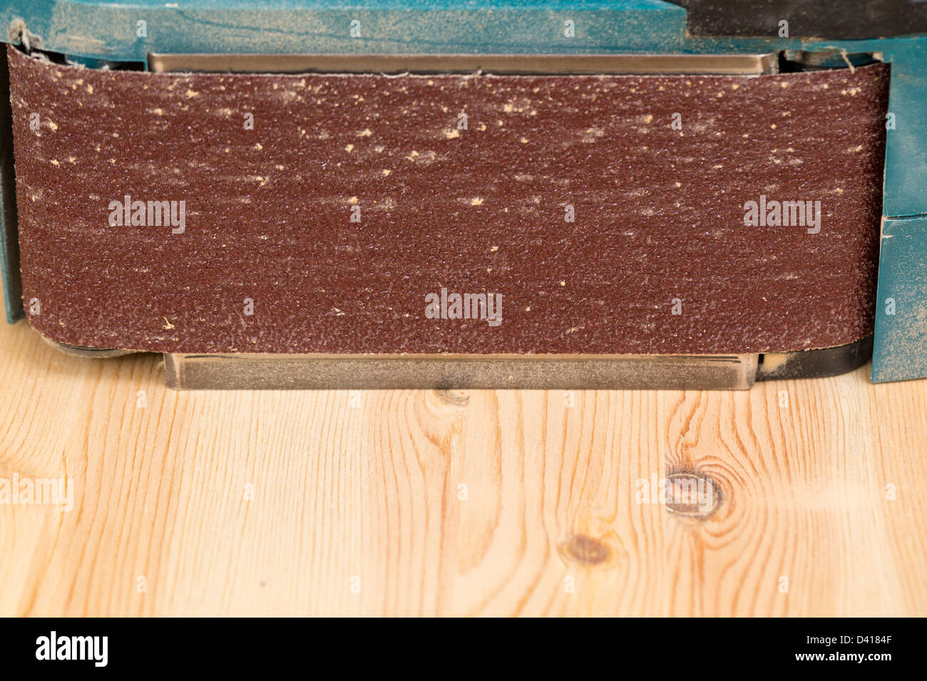 Side view of a belt sander on pine floor or table sanding surface Stock