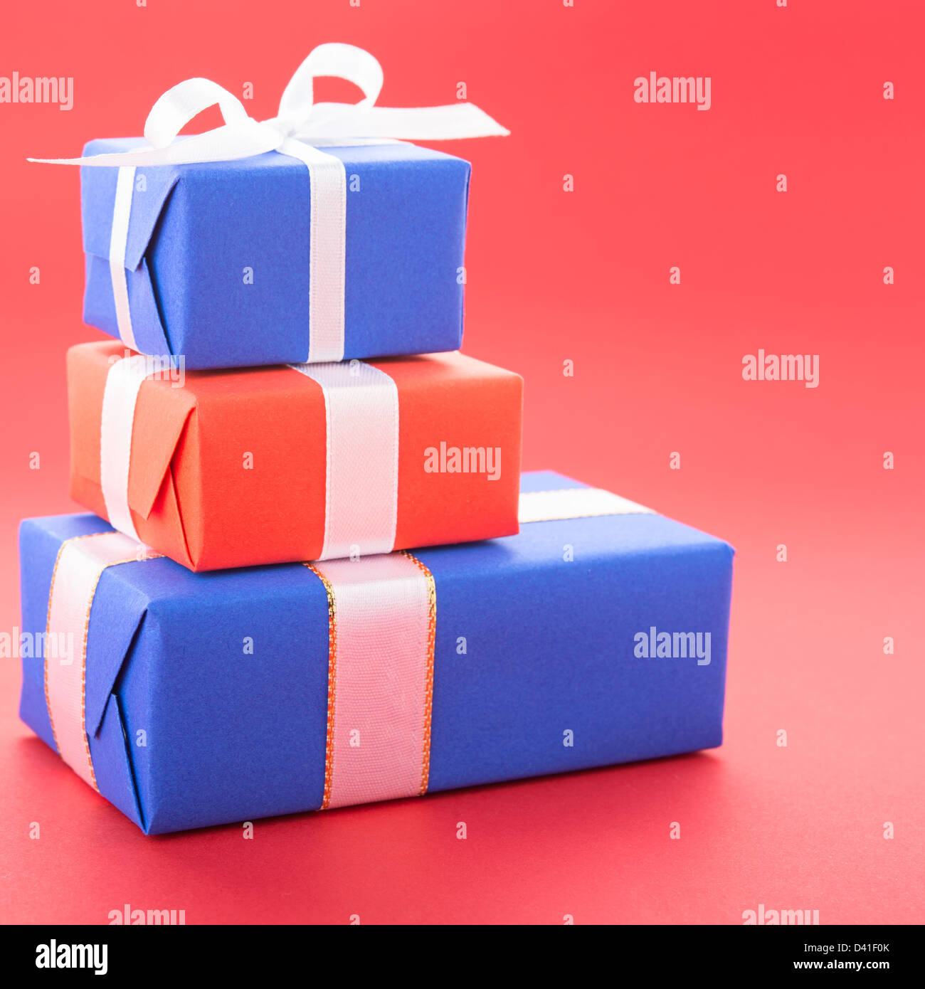 Gift boxes with a bows, isolated on red background Stock Photo - Alamy