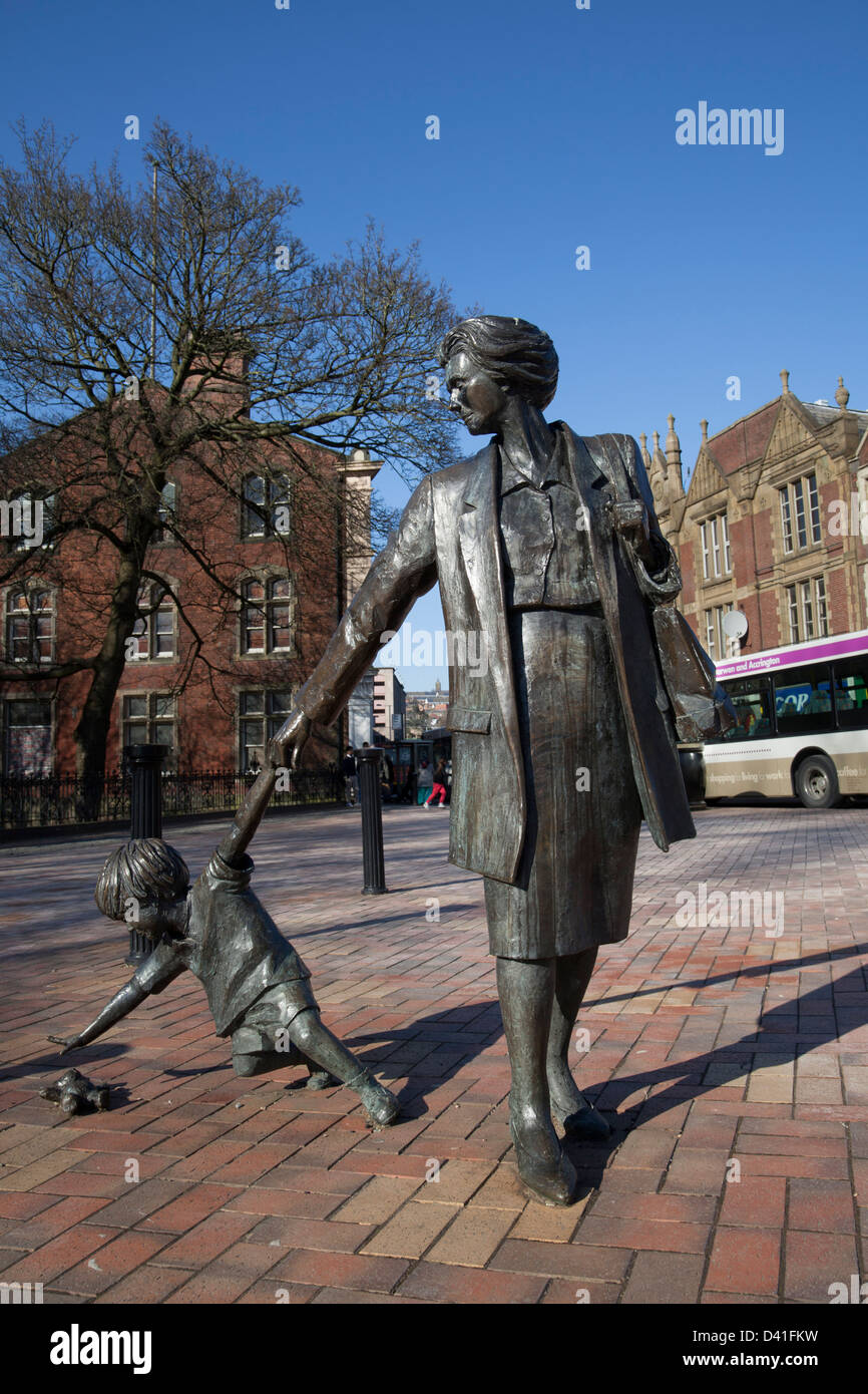 Mother and Child reaching out for teddybear sculpture a 21st Century landmarks for Blackburn Boulevard, Pennine Lancashire, UK Stock Photo