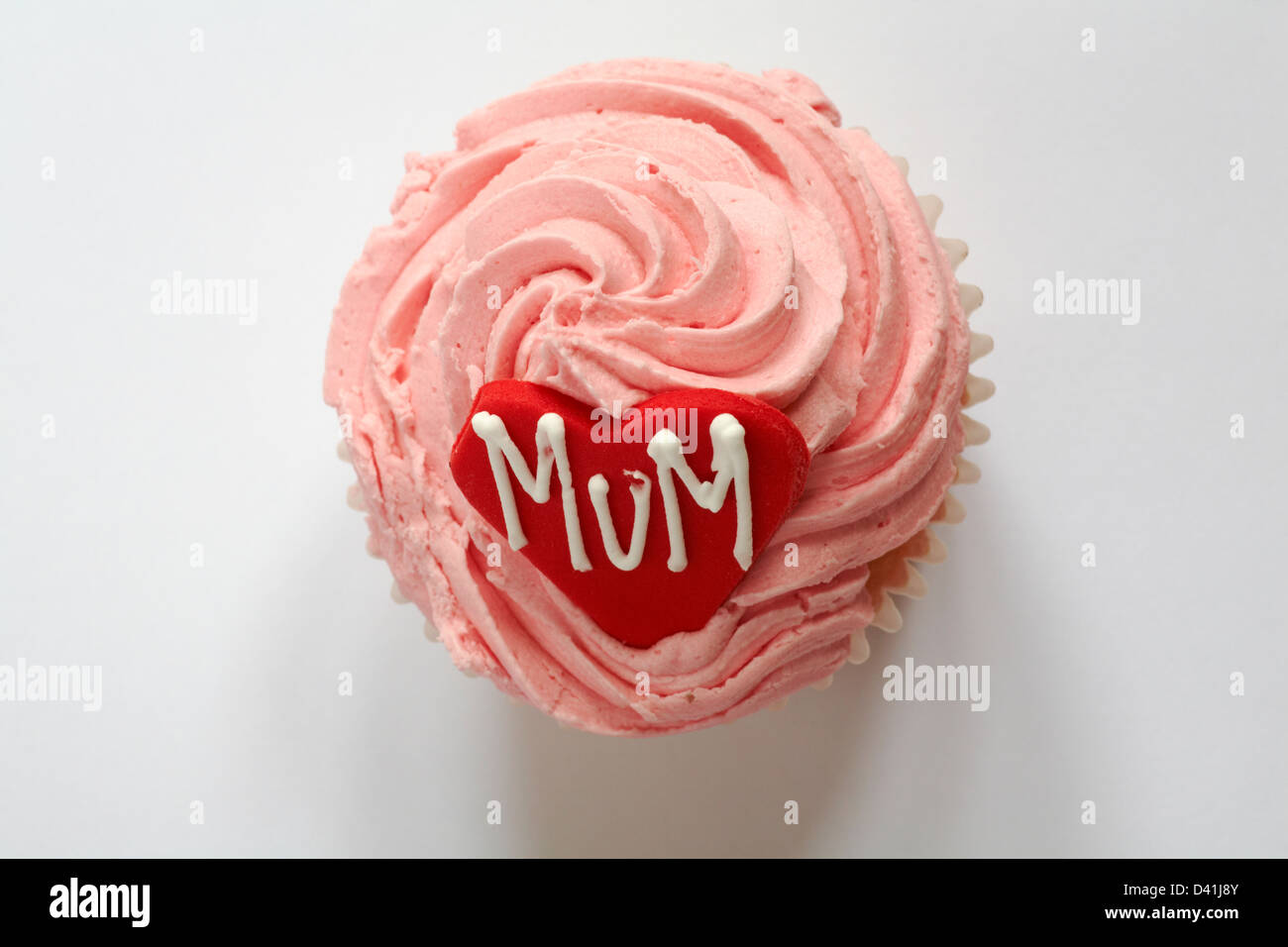 looking down on strawberry cupcake with the word mum iced on red heart for Mothering Sunday, Mothers Day isolated on white background - from above Stock Photo