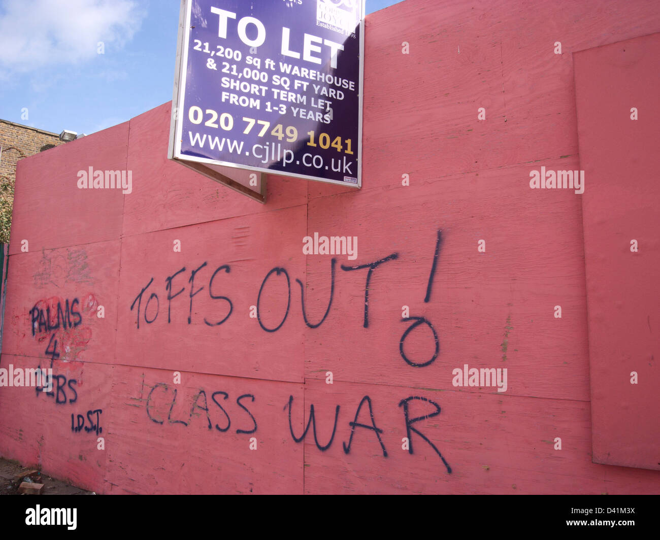 Class war graffiti says TOFFS OUT! in a comment against rich development in a poor area of London, UK. Stock Photo
