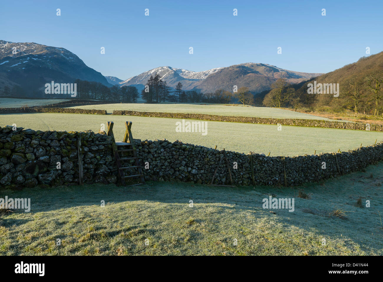 Stile over dry stone wall frosty morning looking towards the Borrowdale Fells, Cumbria, Lake District National Park, England, UK Stock Photo