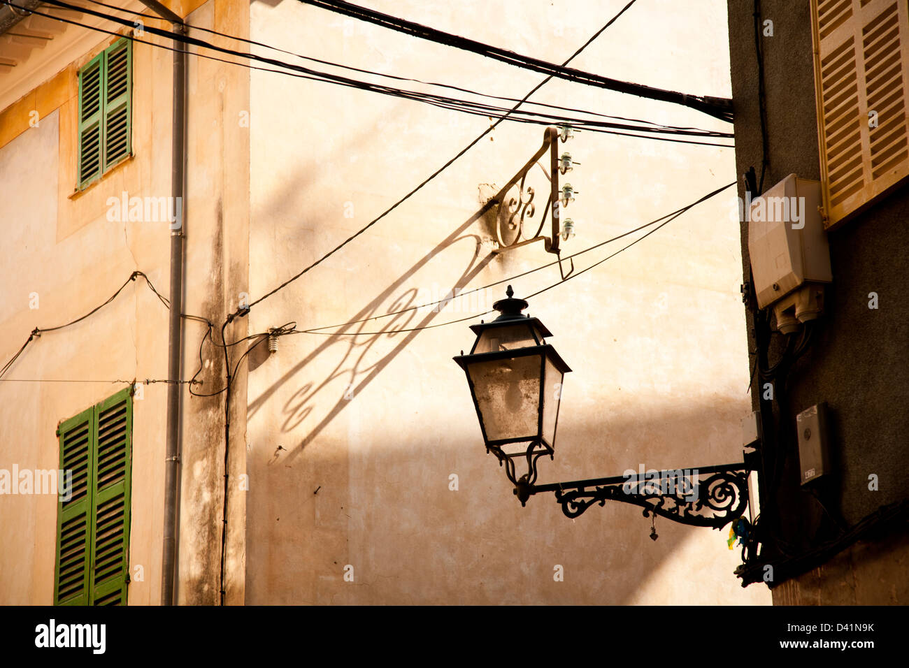 Close-up of buildings in Valldemossa, Majorca, Spain with an ornate street lamp and house with green shutters. Stock Photo